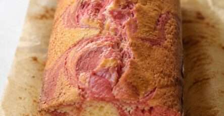 Cake marbré vanille-fraise moelleux avec spirales roses et vanillées dans un moule à cake maison gourmand