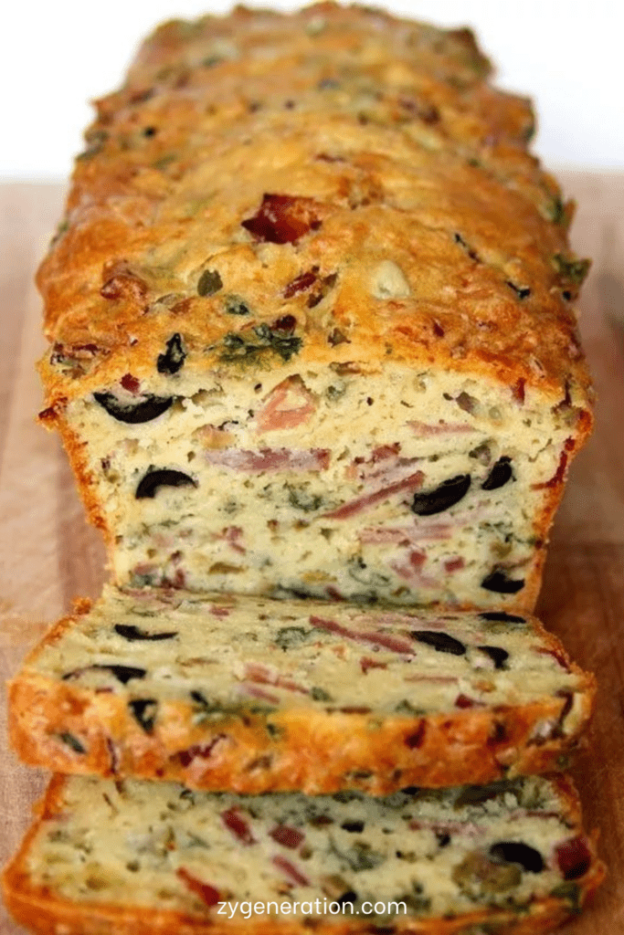 Cake salé doré aux olives noires, olives vertes, bacon et fromage râpé, coupé en tranches moelleuses pour l’apéritif ou un buffet.