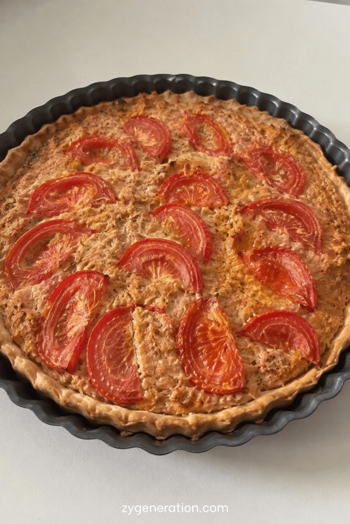 Tarte thon salée, tomates et moutarde avec fromage gratiné dans un moule rustique doré au four
