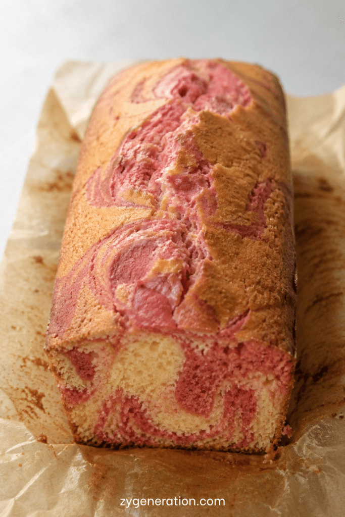 Cake marbré vanille-fraise moelleux avec spirales roses et vanillées dans un moule à cake maison gourmand