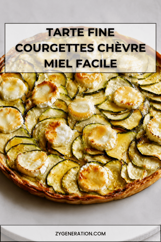 Tarte fine aux courgettes, chèvre et miel sur pâte feuilletée dorée, garnie de rondelles de courgettes, fromage de chèvre fondu et filet de miel.