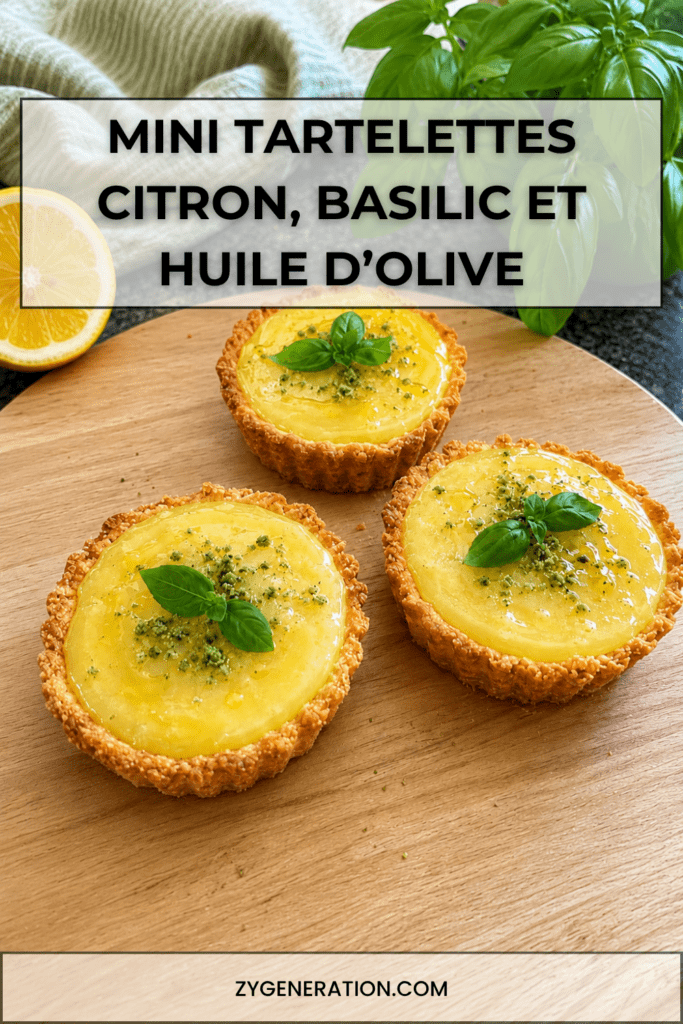 Mini tartelettes au citron maison garnies de crème citron brillante, d’un filet d’huile d’olive douce et de feuilles de basilic frais.