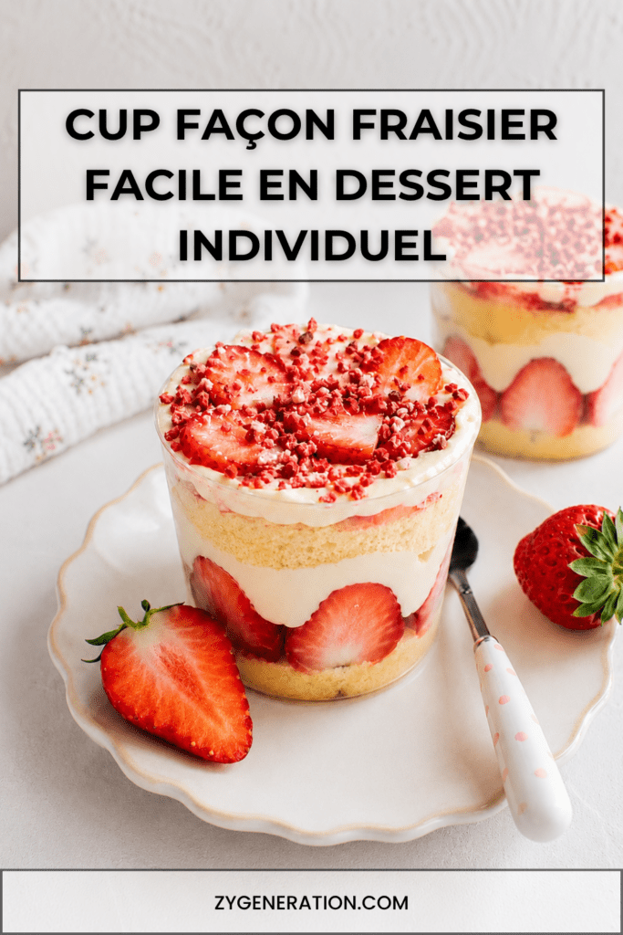 Cup façon fraisier servie dans un verre avec couches de génoise moelleuse, fraises fraîches coupées, crème vanille, chantilly et miettes de fraises séchées.