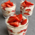 Verrines de tiramisu aux fraises avec crème mascarpone onctueuse, morceaux de fraises fraîches et biscuits à la cuillère, servies bien froides.