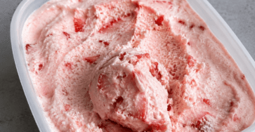 Glace maison à la fraise sans sorbetière, servie en boules crémeuses avec une couleur rose naturelle et des fraises fraîches.