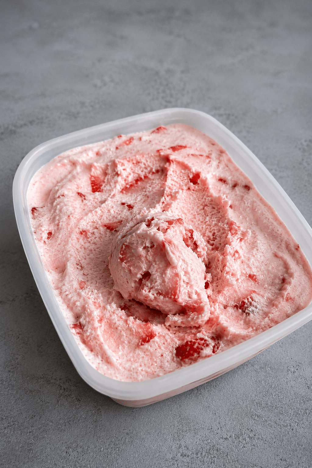Glace maison à la fraise sans sorbetière, servie en boules crémeuses avec une couleur rose naturelle et des fraises fraîches.