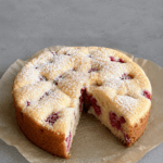 Gâteau moelleux citron framboise sans beurre, doré au four, avec une mie légère, des framboises visibles et un zeste de citron frais.