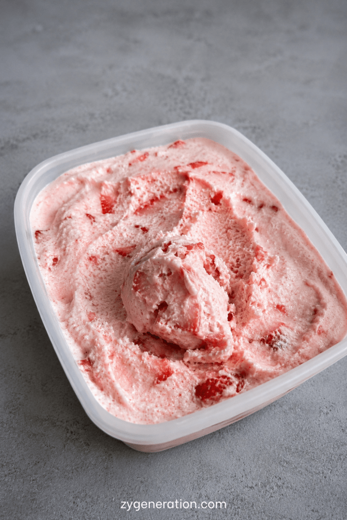 Glace maison à la fraise sans sorbetière, servie en boules crémeuses avec une couleur rose naturelle et des fraises fraîches.