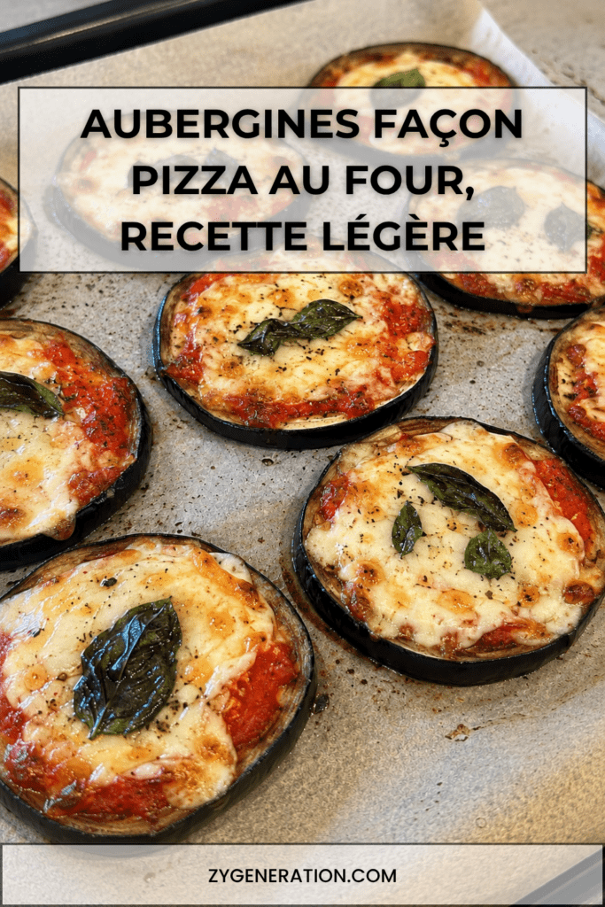 Rondelles épaisses d’aubergines façon pizza gratinées au four avec sauce tomate, mozzarella fondue, origan et feuilles de basilic frais.