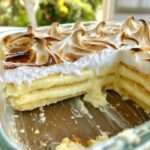 Grand dessert citron meringué servi dans un plat à gratin, avec couches de biscuits fondants, crème citron onctueuse et meringue dorée.