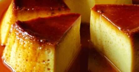 Flan caramel façon grand-mère démoulé sur un plat blanc, nappé de caramel doré brillant, avec une texture lisse et fondante.