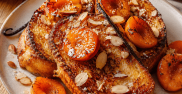 Une brioche dorée et moelleuse, accompagnée d’abricots caramélisés, d’amandes grillées et d’une touche de vanille.