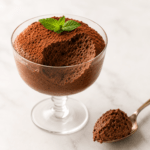 Mousse au chocolat aérienne servie dans des verrines en verre, avec une texture légère et mousseuse, des copeaux de chocolat noir et une fine couche de cacao.