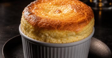 Soufflé au fromage express servi dans des ramequins individuels, très gonflé au-dessus des bords, avec une surface dorée et un intérieur léger et crémeux.