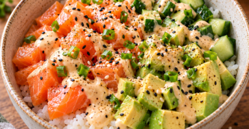 Bowl de riz au saumon avec tranches d’avocat, dés de concombre et sauce crémeuse à la mayonnaise, sauce soja et citron.
