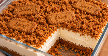 Cheesecake individuel sans cuisson au yaourt grec, avec base de biscuits Biscoff émiettés, miettes croustillantes et biscuit entier sur le dessus.