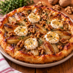 Tatin salée aux endives caramélisées, fromage de chèvre fondant, miel et noix croquantes, sur une pâte feuilletée dorée et croustillante, servie dans un plat rustique.