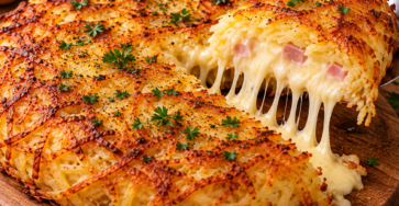 Galette de pommes de terre râpées bien dorée à la poêle, coupée pour révéler un cœur généreux de reblochon fondu.